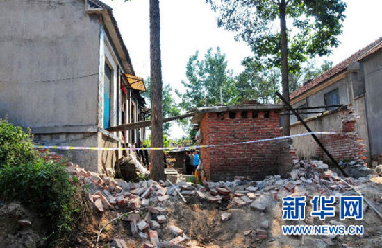  山东平邑县一农民被烧死事件调查死者张纪民家的西侧院墙被推倒，并已拉上了警戒线 新华社记者张志龙摄