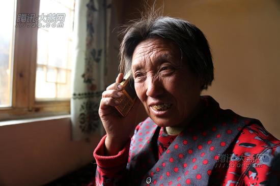 唐荣斌老伴吴宝青用手机与儿子通话。腾讯大燕网 寇家祥 摄