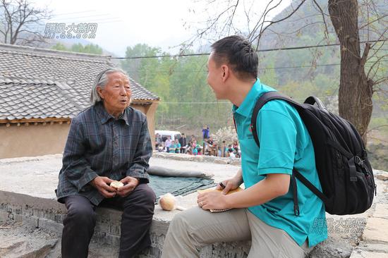 骆驼湾村村民王静蓉（音）正接受网络媒体采访。腾讯大燕网 寇家祥 摄