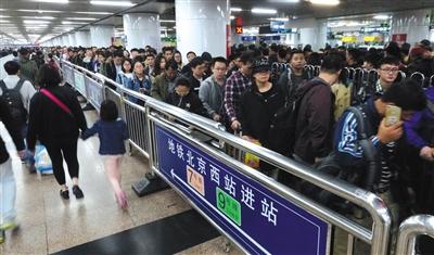 昨日，旅客在北京西站出站后，准备乘地铁离开站区，候乘队伍蜿蜒距离超过300米。图/视觉中国